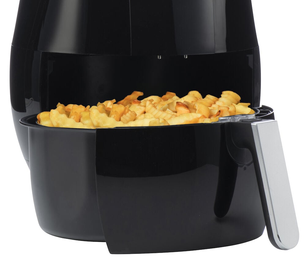 Svart airfryer med pommes frites i korgen.