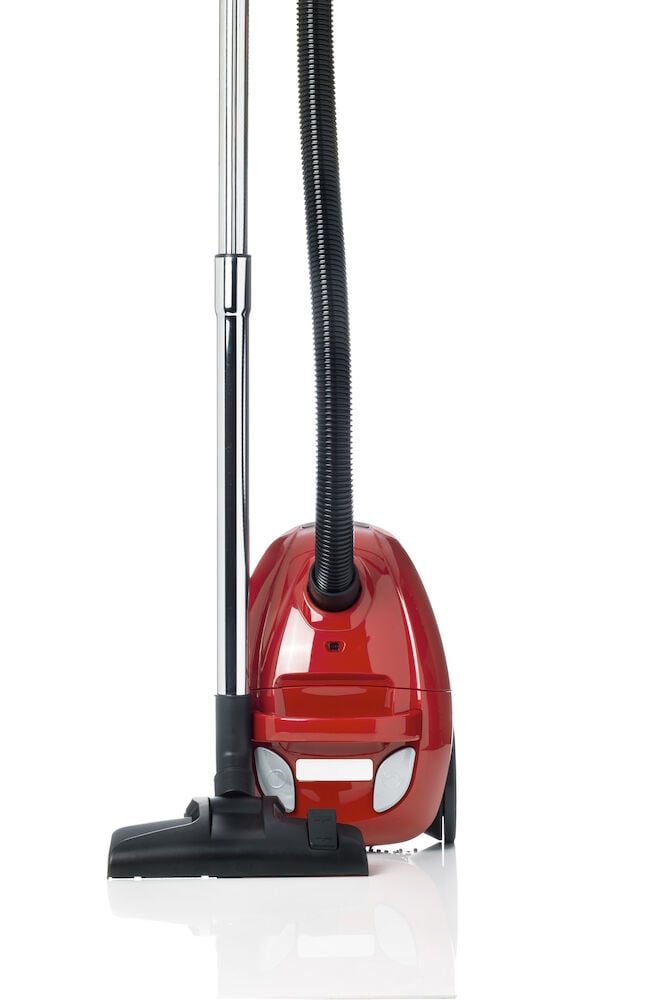Röd dammsugare med slang och golvmunstycke.