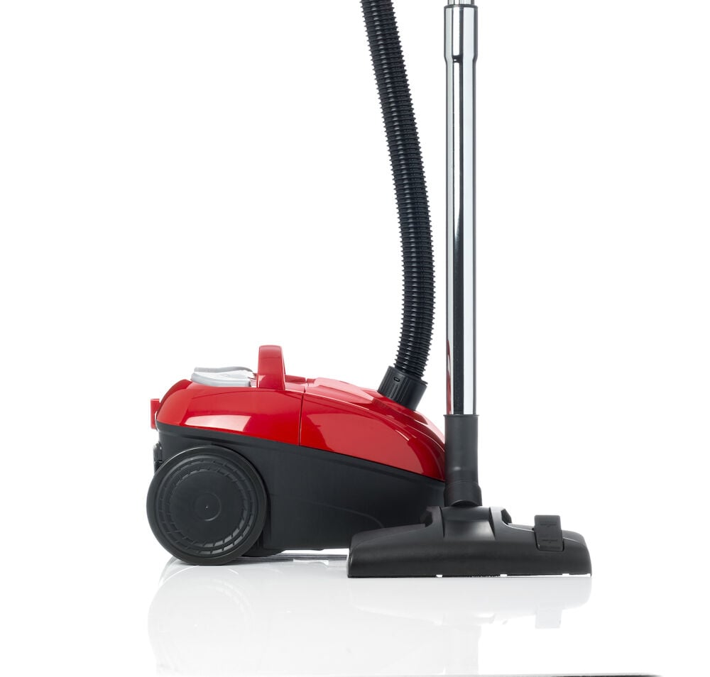 Röd dammsugare med svart munstycke och slang.