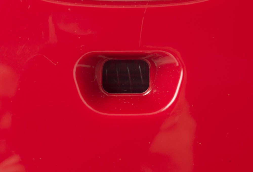 Rött ventilationsgaller på dammsugare i plast.