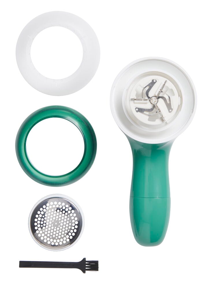 Grüner Fusselentferner mit Zubehör und Reinigungsbürste.