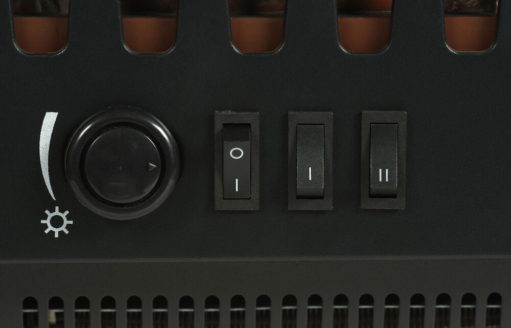 Svart kontrollpanel med tre strömbrytare och vred.