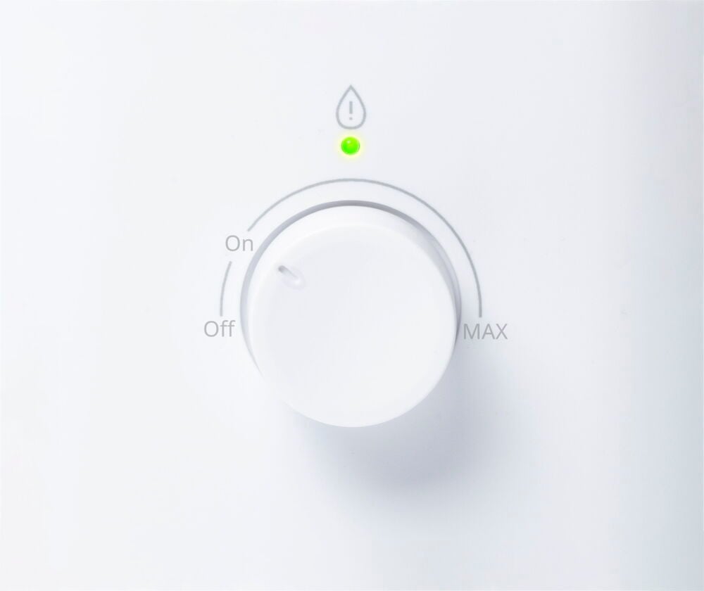 Vit luftfuktare med rund vred och grön indikator.