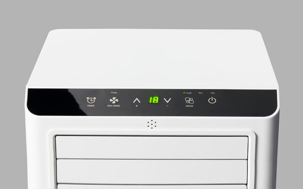 Valkoinen kannettava ilmastointilaite, jossa on digitaalinen ohjauspaneeli.