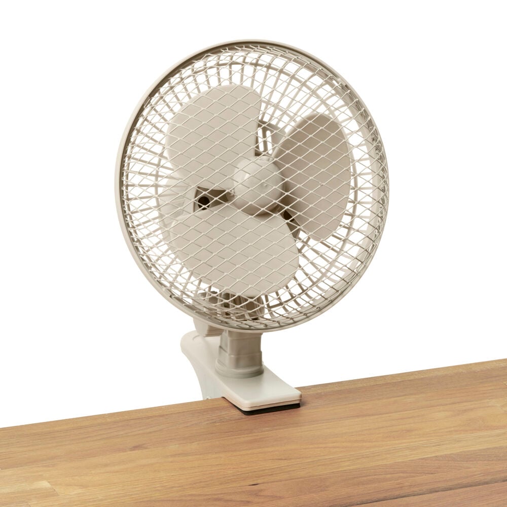 Valkoinen pöytätuuletin, jossa on puristin puupöydällä.