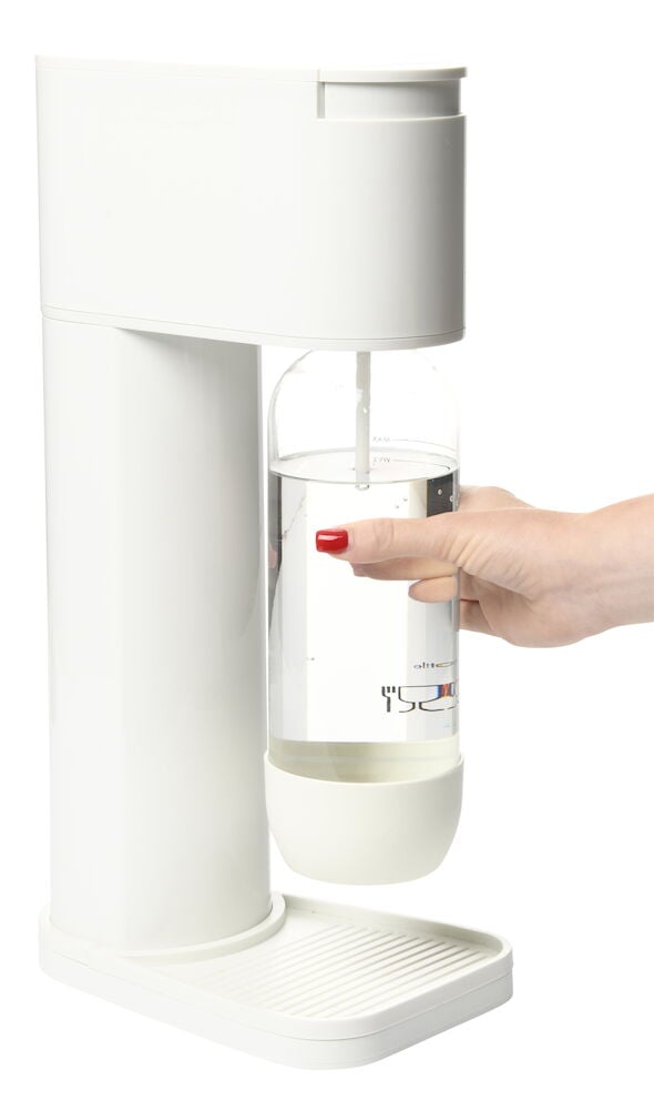 Vit kolsyremaskin med PET-flaska och hand som håller flaskan.