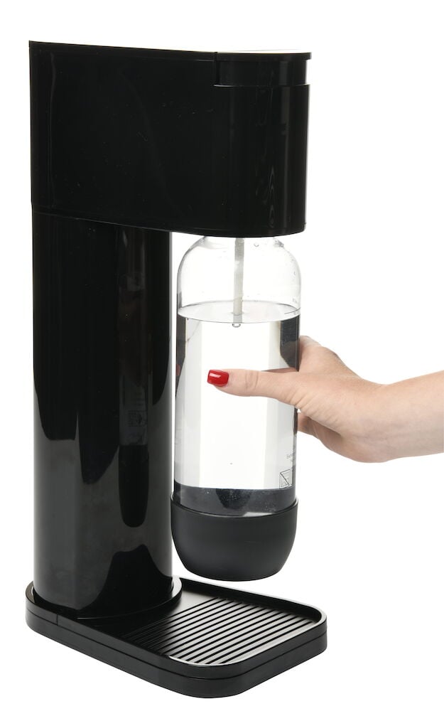 Svart kolsyremaskin med genomskinlig flaska och hand.