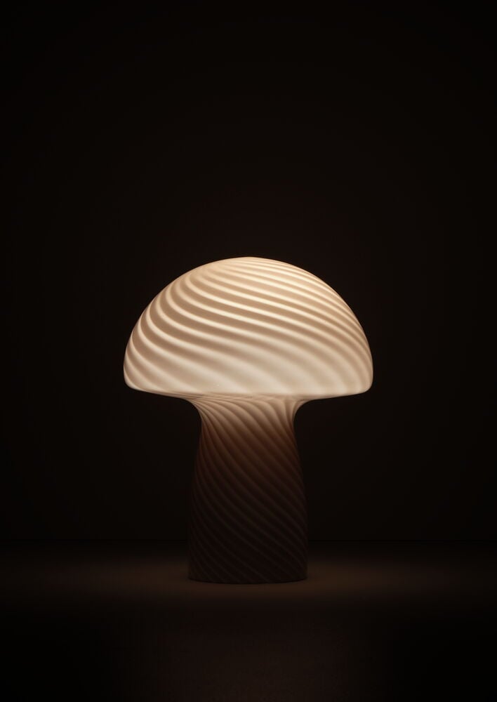 Rosa glaslampa med svampformad design lyser upp.