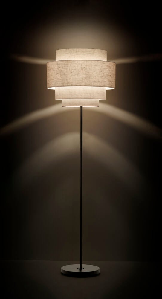 Golvlampa med svart stativ och stor linneskärm.