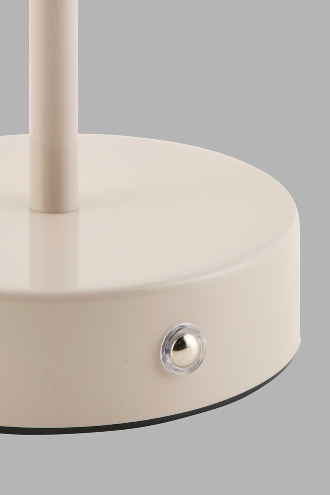 Beige bordsfot med metallknapp på sidan.