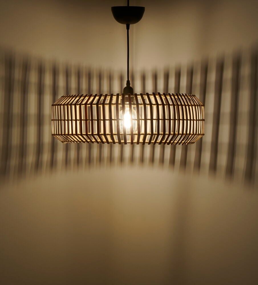 Pyöreä bambukattolamppu, jossa on valo- ja varjokuvioita.