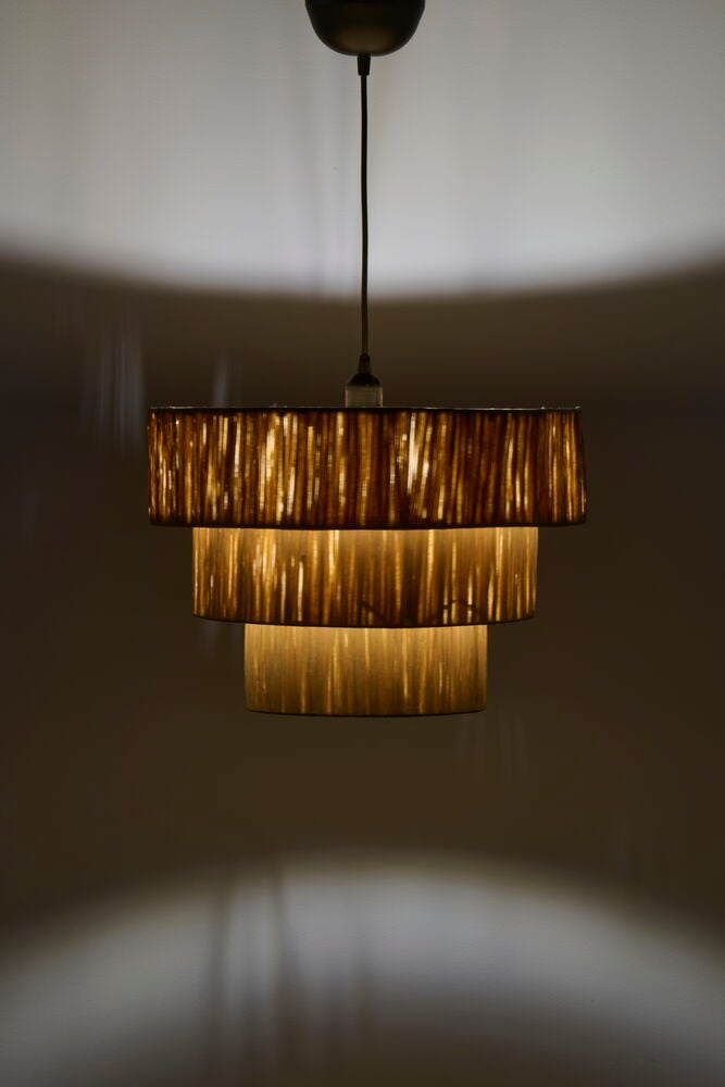 Flerskiktad taklampa av papper med varm belysning.