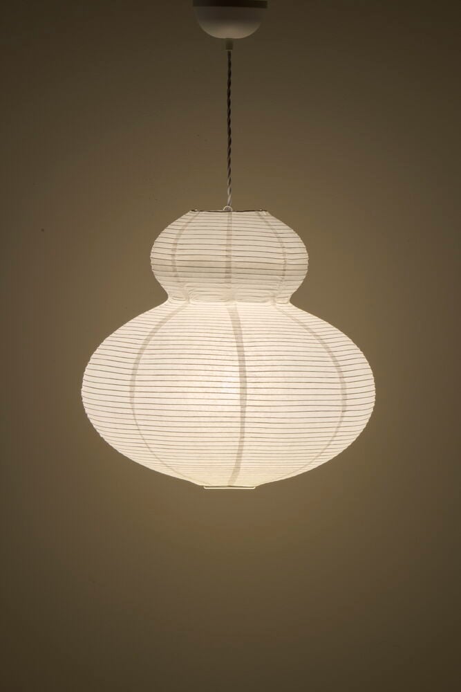 Vit rispapperslampa i traditionell form hängande från tak.
