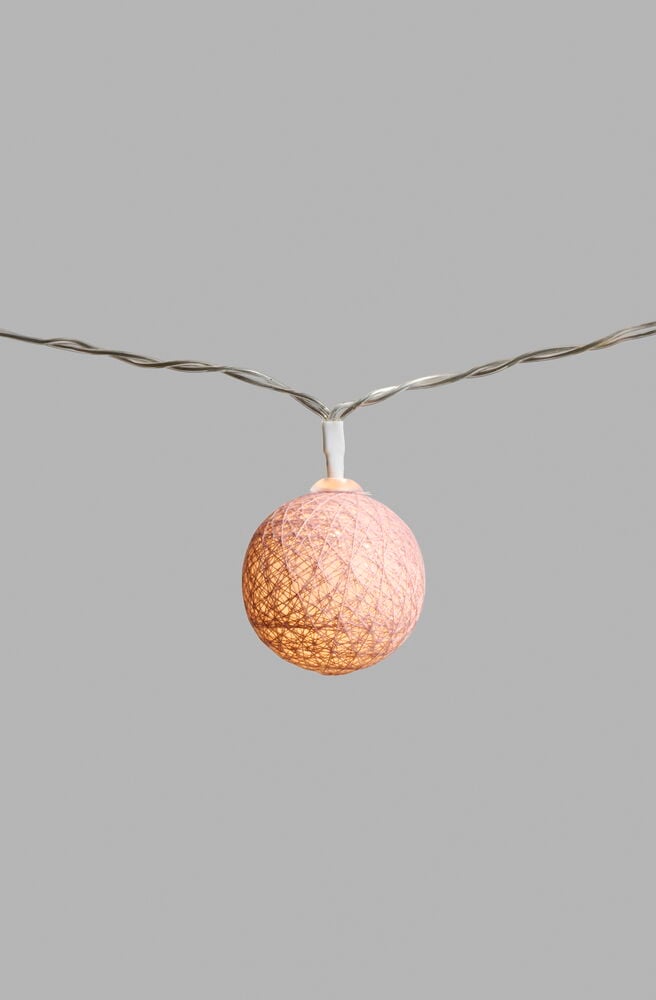 Eine einzelne leuchtende staubrosa Kugel einer LED-Lichterkette Lysa Dusty Pink Mini.