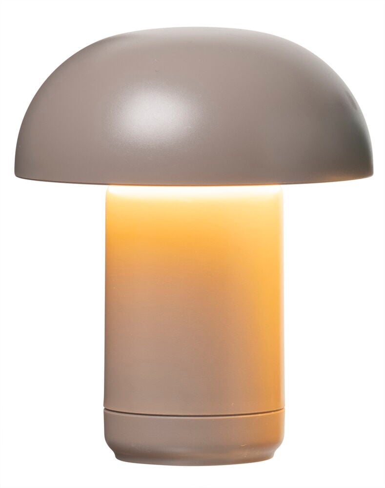 Liten bordslampa i plast med svagt gult sken.