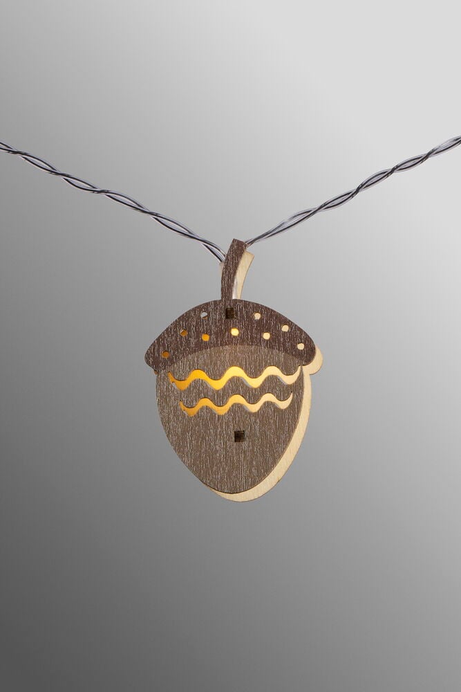 Ekollonformad lampa i trä med dekorativa mönster.