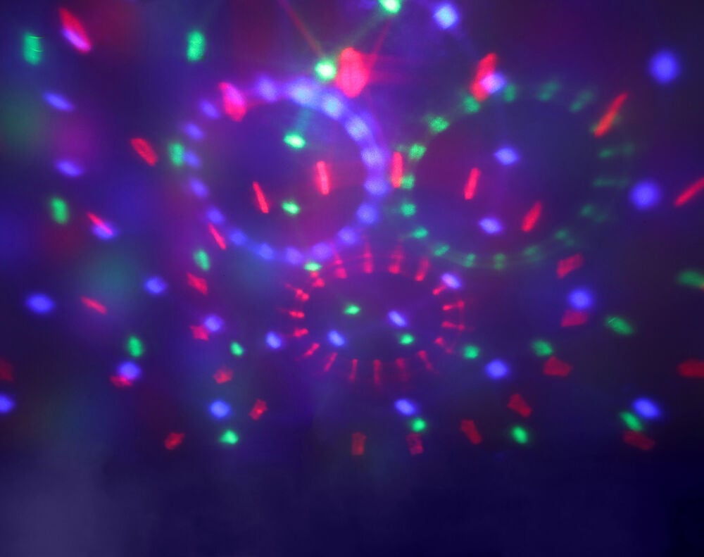 Discolampa LED Ambiance projicerar färgglada röda, gröna, blå ljusmönster och cirklar på en mörk bakgrund.
