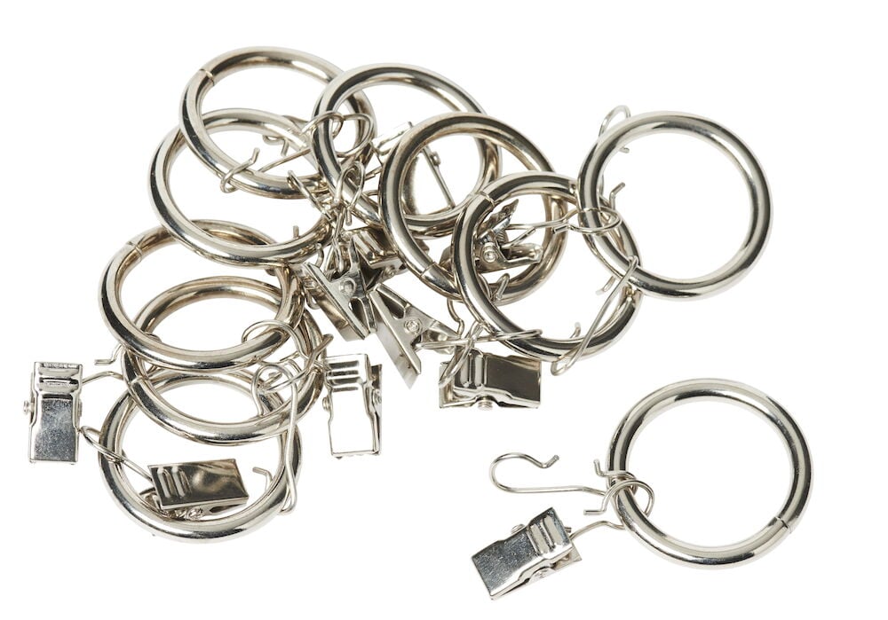 Kymmenen hopeanväristä metalliverhorengasta puristimilla.