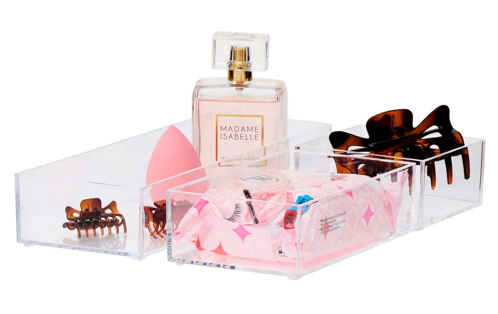 Tre genomskinliga förvaringslådor med olika accessoarer.