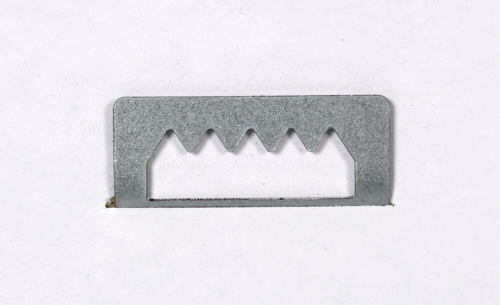 Metallupphängare med sågtandad kant för väggmontering.