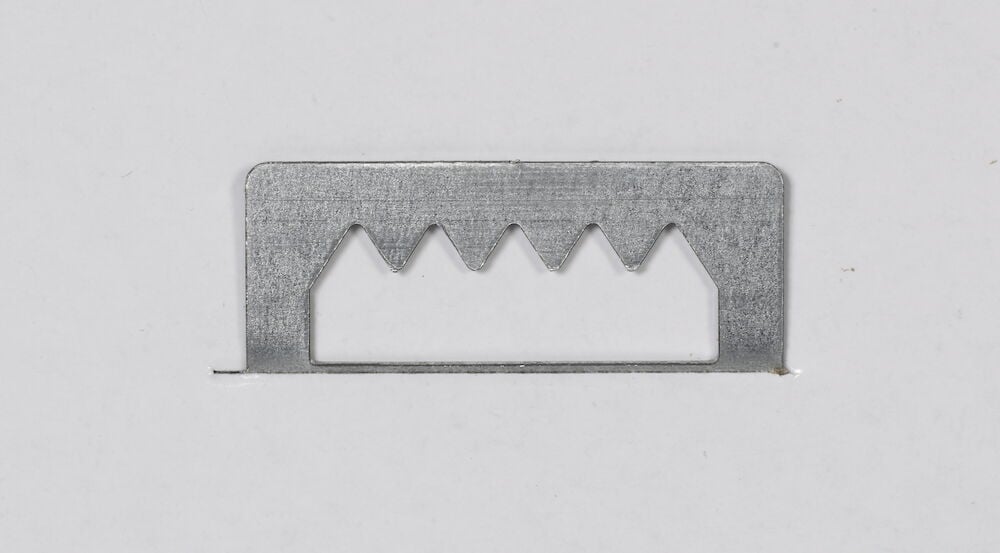 Metallfäste med taggar för väggmontering.