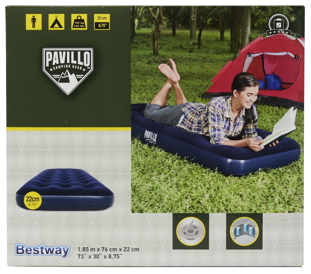 Person ligger på blå luftmadrass utomhus vid tält.