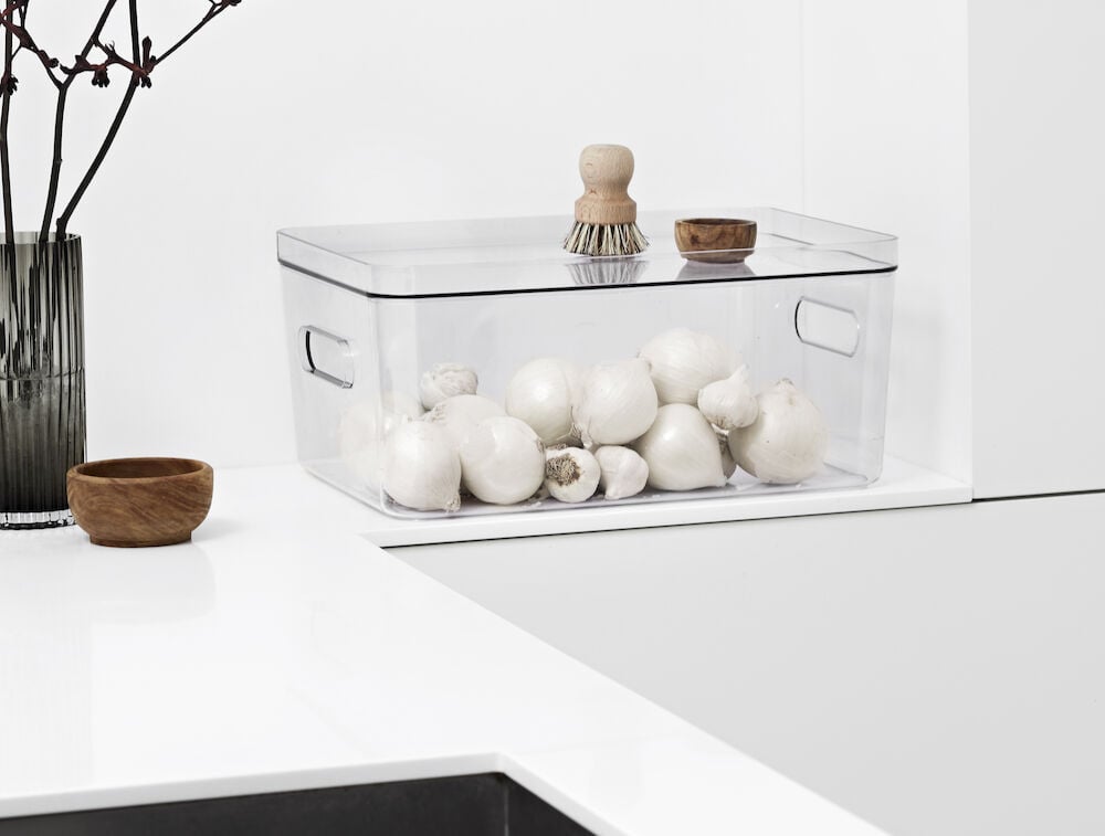 Transparent plastlåda med lock innehåller färska champinjoner.