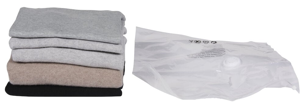 Vikta kläder bredvid genomskinlig vakuumpåse.