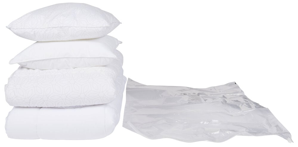 Transparent vakuumpåse bredvid vita kuddar och täcken.