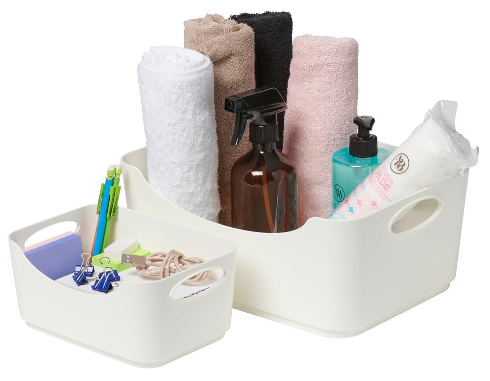 Kaksi valkoista avointa säilytyslaatikkoa, joissa on eri sisältö.