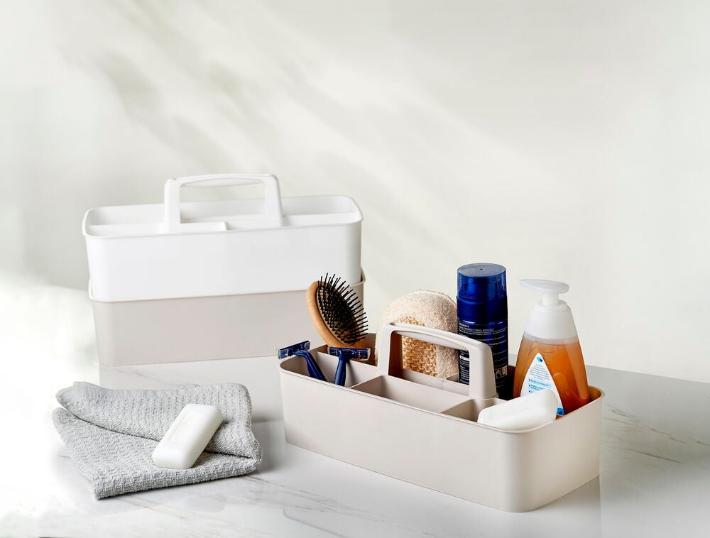 Säilytyslaatikko, jossa kahvat ja useita lokeroita, eri värejä.