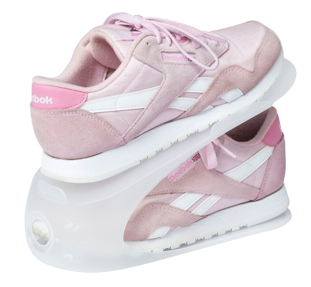 Zwei rosa Turnschuhe gestapelt auf einem transparenten Schuhhalter.