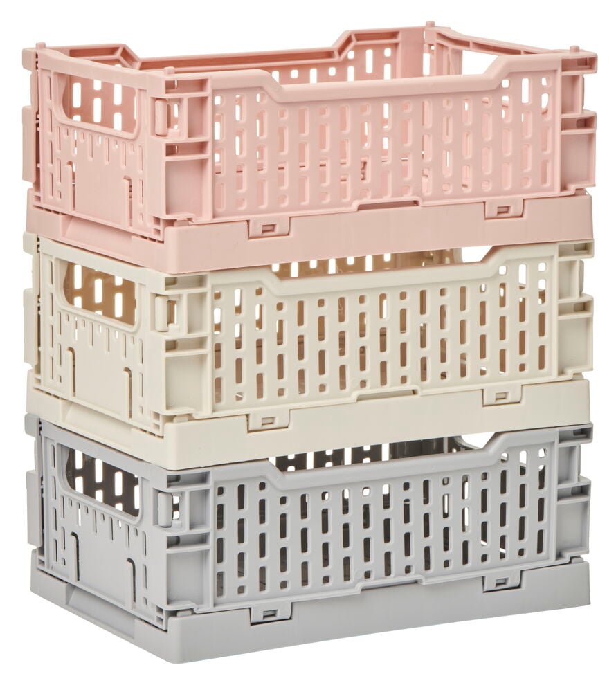 Tre staplade plastbackar i olika pastellfärger.