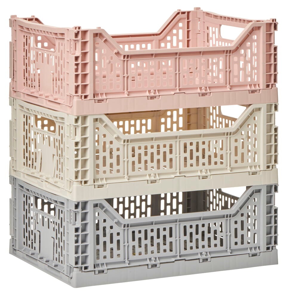 Tre staplade hopfällbara plastbackar i olika färger.