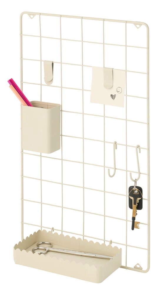 Beige rutig anslagstavla med pennhållare, klämma med lapp, S-krokar med nycklar och en sax i bricka.