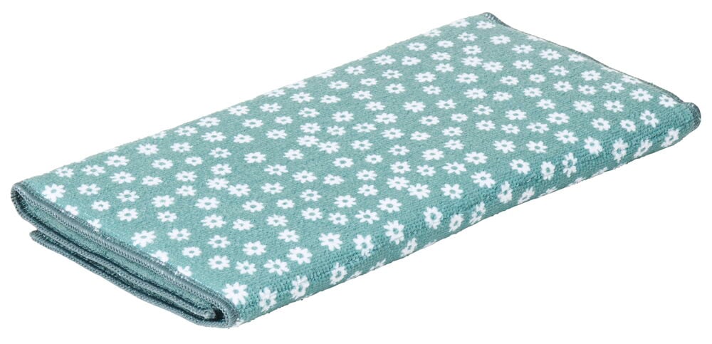 Grönt diskunderlägg med vita blommor vikt ihop.