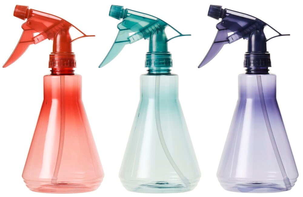 Tre sprayflaskor i rött, grönt och lila.
