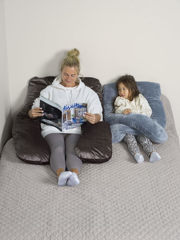 Nainen ja lapsi U-muotoisella vartalotyynyllä.