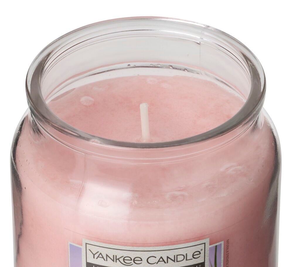 Vaaleanpunainen Tuoksukynttilä Yankee Candle 340 g Pink Island Sunset kirkkaassa lasipurkissa valkoisella sydämellä.