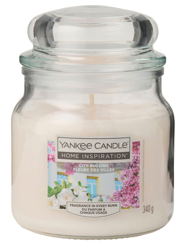 Hvitt duftlys Yankee Candle 340 g City Blooms, med klart glasslokk og blomsteretikett.