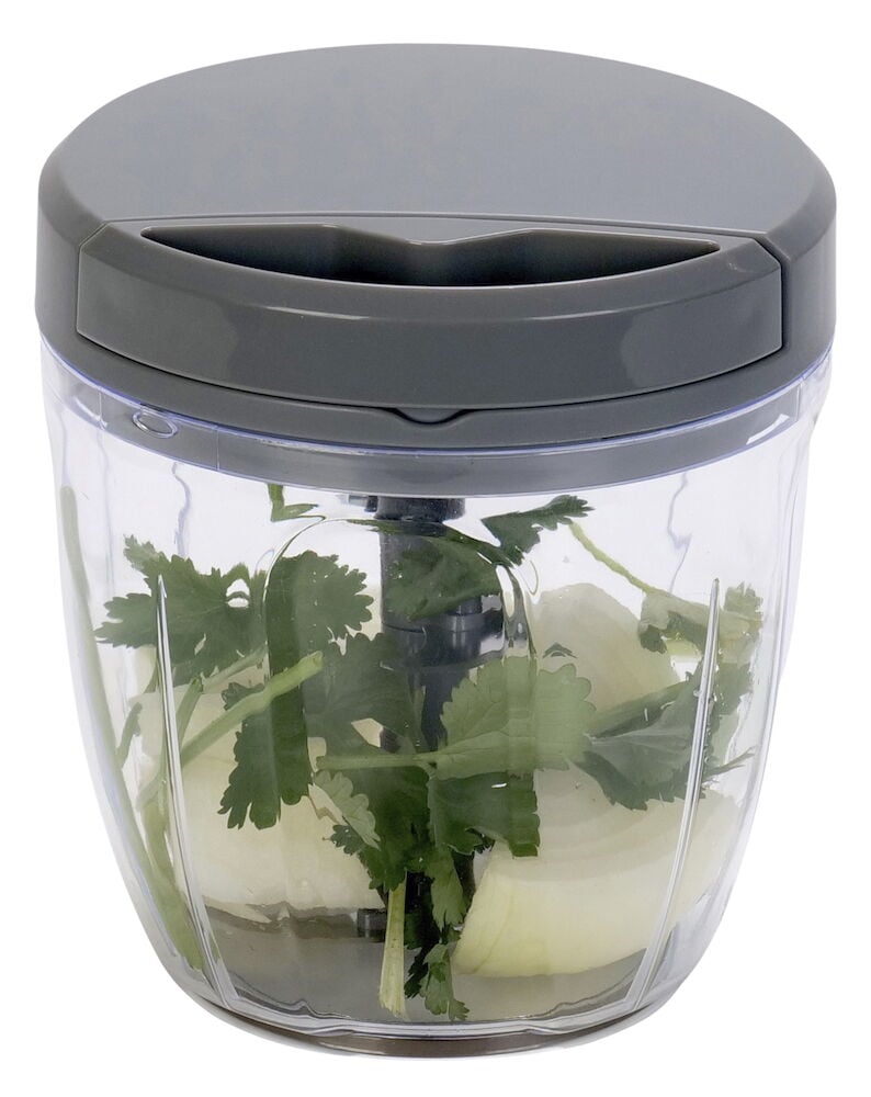 Manueller Mini-Hacker mit Zwiebel und Blattpetersilie.