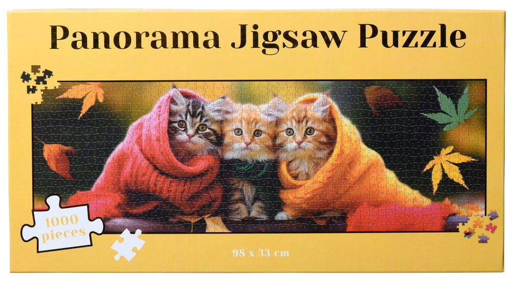 Tre kattungar i filtar på ett pussel.