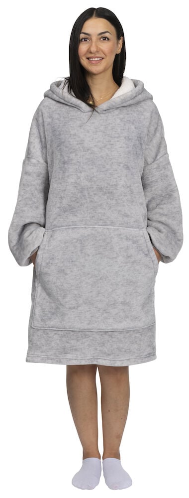 Nainen vaaleanharmaassa oversized-hupparissa, jossa on taskut.