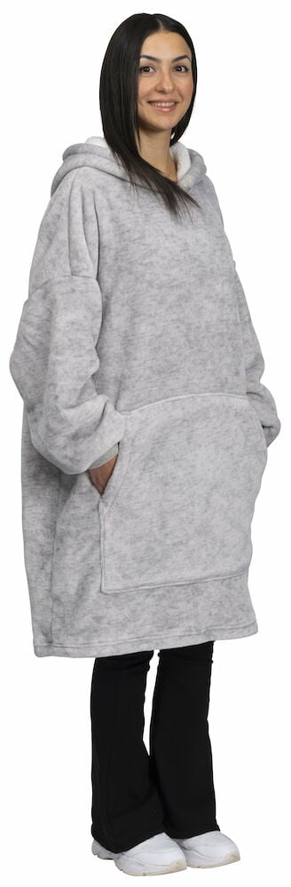 Nainen vaaleanharmaassa, ylisuuren koossa olevassa hupparissa, jossa on huppu.