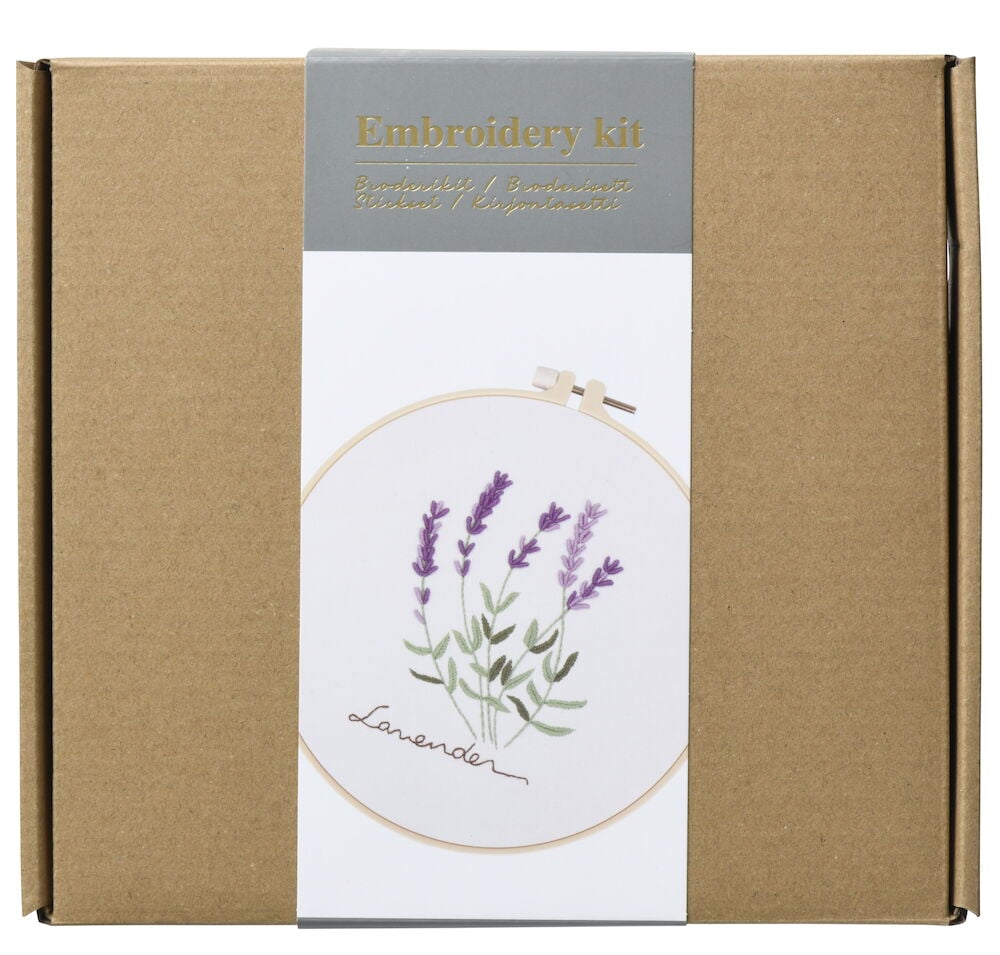 Brun kartong med broderikit lavendermotiv på etiketten.