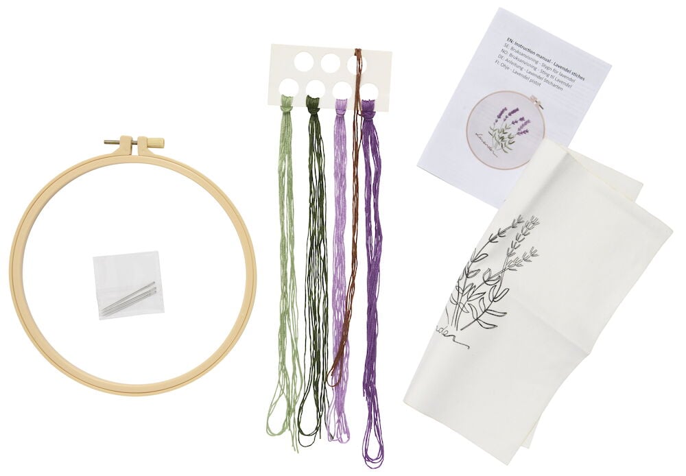 Broderikit med båge, nålar, tråd och mönstrad tygbit.