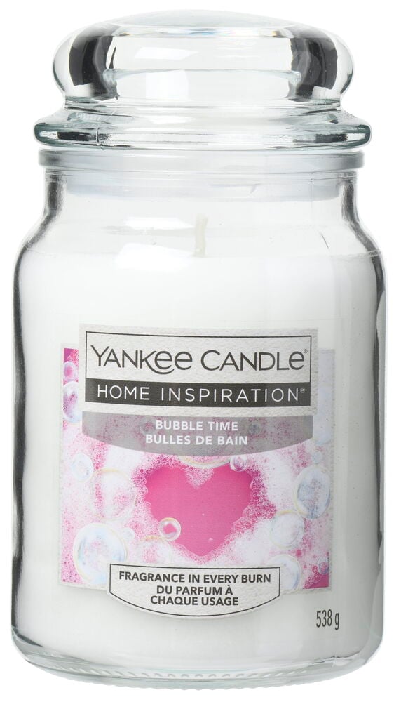 Stor glasskrukke med hvit duftlys og rosa etikett.