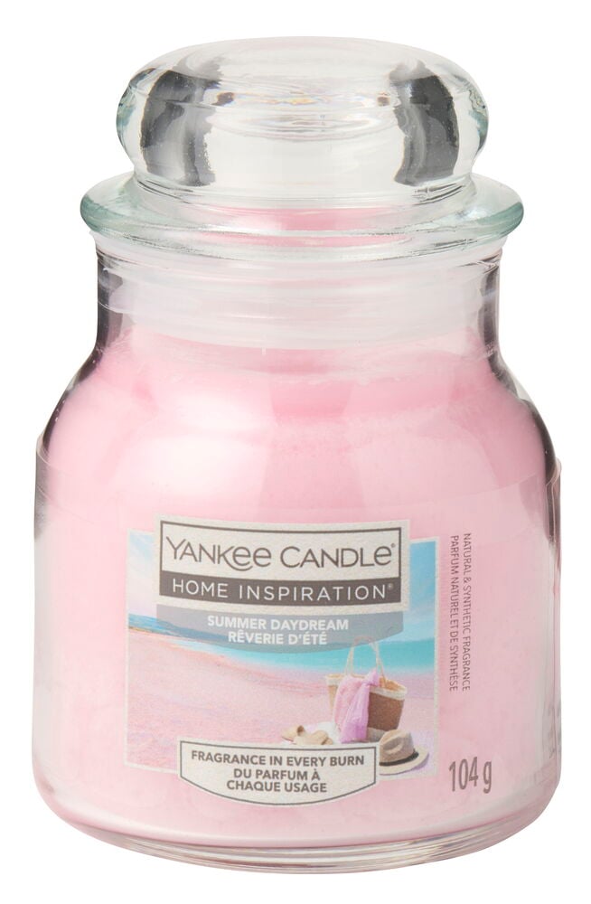 Et rosa duftlys i et klart glass med lokk, med etiketten Summer Daydream.
