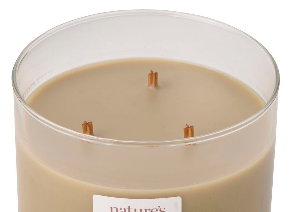 Närbild av ett doftljus WoodWick Golden Hay i klar glasburk med tre vekar, ljusbrunt vax.