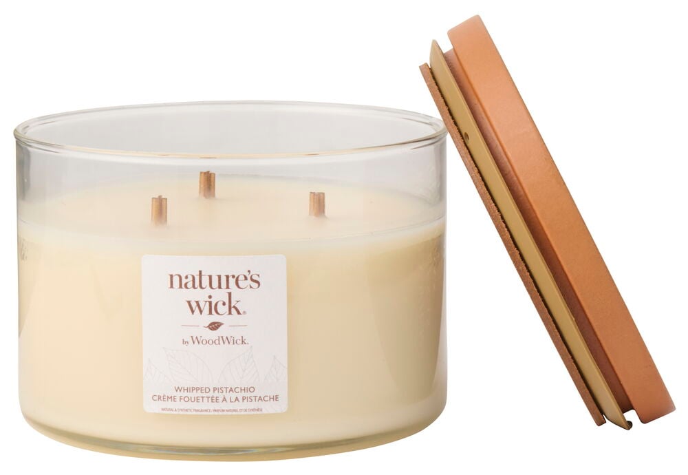 Doftljus WoodWick Whipped Pistachio i en klar glasburk med tre trävekar och ett brunt lock.